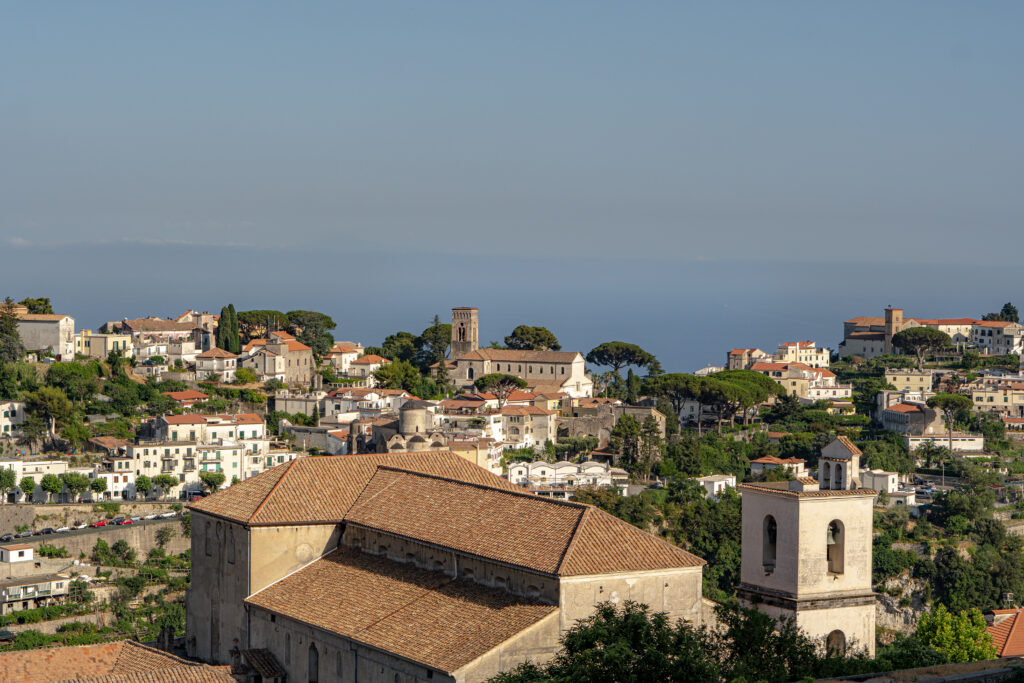 Skyline view of rooftops along the Amalfi coast with clear blue sky and orange and white hues of the houses and roofs